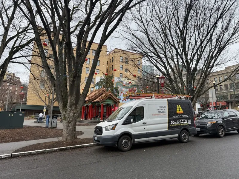 Aztec Electric service van parked near a commercial job site